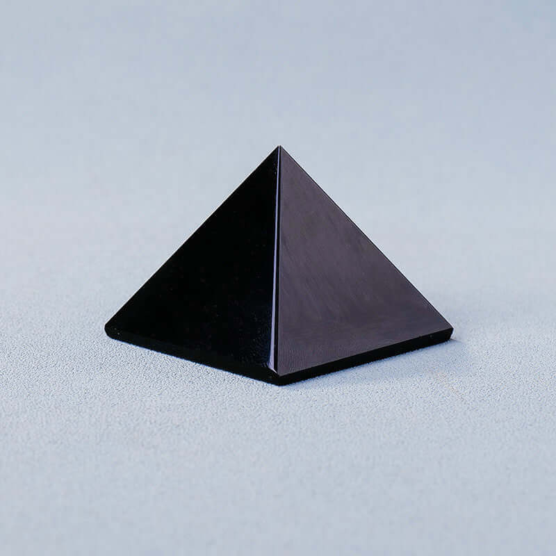 Black crystal stone pyramid ornament for meditation and mindfulness energy generation.